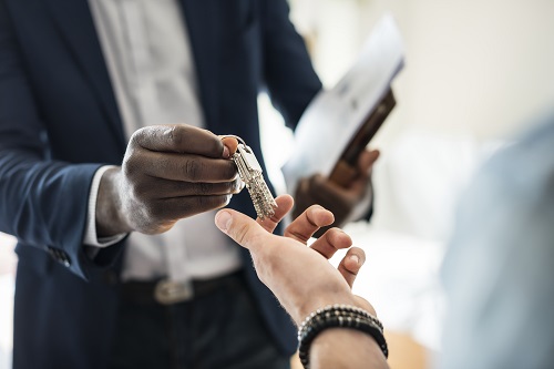 real-estate-agent-handing-house-key-client