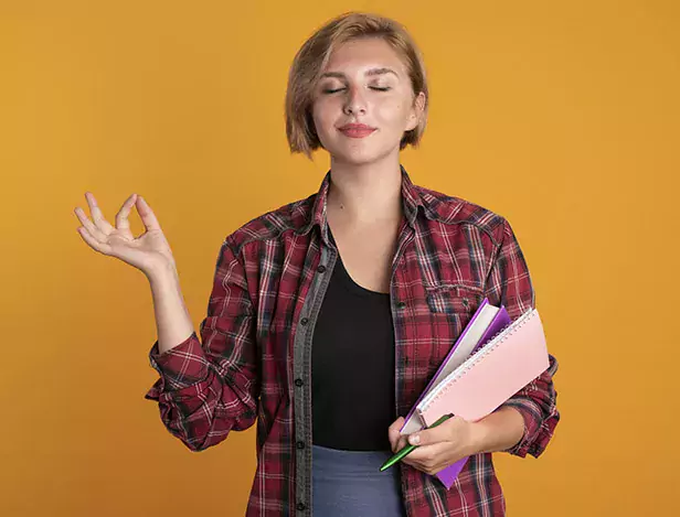 pleased-young-slavic-student-girl-holds-pen-book-notebook-pretends-meditate-with-closed-eyes