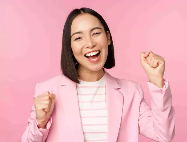 enthusiastic-saleswoman-asian-corporate-woman-say-yes-achieve-goal-and-celebrating-triumphing-looking-with-rejoice-and-smiling-standing-over-pink-background-compressed-1