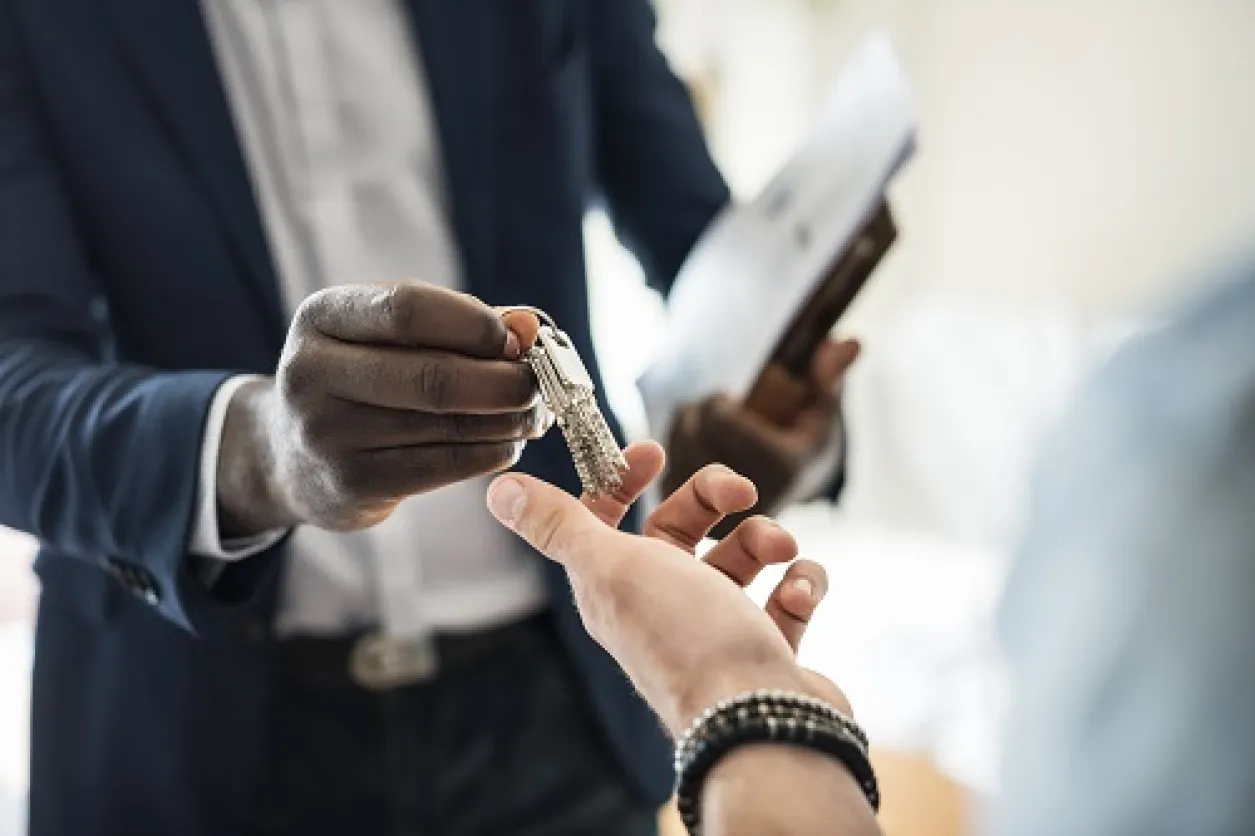 se former en immobilier real-estate-agent-handing-house-key-client